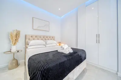 a bedroom with a bed with white walls at Infinity penthouse in Koukaki in Athens