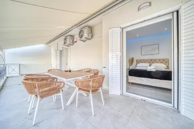 a dining room with a table and chairs and a bed at Infinity penthouse in Koukaki in Athens