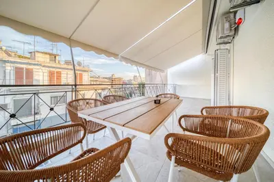 a balcony with a wooden table and chairs at Infinity penthouse in Koukaki in Athens