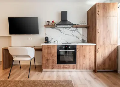 a kitchen with a stove and a chair and a tv at ATELIER 33 , Acropolis Apartments in Athens