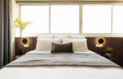 a bedroom with a large bed with two windows at ATELIER 33 , Acropolis Apartments in Athens