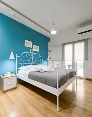 a bedroom with a bed and a blue wall at Modern&Stylish 1BD apt next metro and Acropolis in Athens