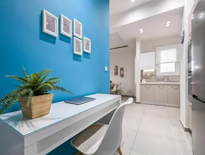 a blue wall in a kitchen with a desk and a plant at Modern&Stylish 1BD apt next metro and Acropolis in Athens