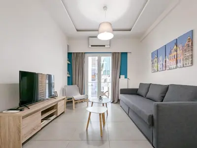 a living room with a couch and a television at Modern&Stylish 1BD apt next metro and Acropolis in Athens