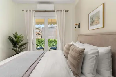 a bedroom with a bed with white pillows and a window at Elegant&Cozy 2BD Historic Center next to metro in Athens