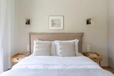 a bedroom with a bed with white sheets and pillows at Elegant&Cozy 2BD Historic Center next to metro in Athens