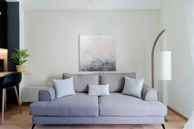 a living room with a gray couch with pillows at Elegant&Cozy 2BD Historic Center next to metro in Athens