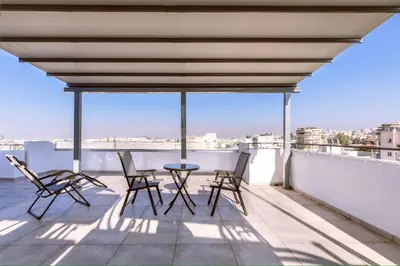 a patio with chairs and a table on a roof at M&H and their friends 2 in Athens