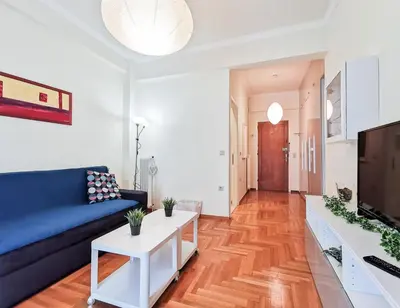 a living room with a blue couch and a white table at Modern&Sunny, 1BD, next to metro in Athens