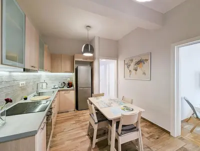 a kitchen with a table and chairs and a refrigerator at Modern&Quiet 2BD apt on a pedestrian in Athens