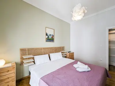 a bedroom with a large bed with a purple blanket at Modern&Quiet 2BD apt on a pedestrian in Athens
