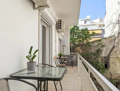 a balcony with a table and chairs on it at Modern&Quiet 2BD apt on a pedestrian in Athens