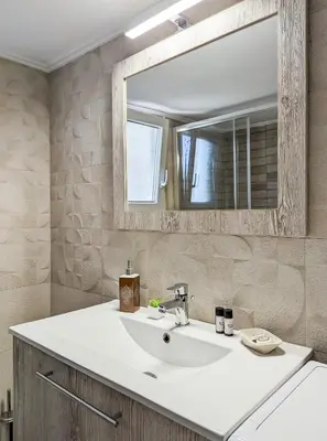 a bathroom with a white sink and a mirror at Modern&Quiet 2BD apt on a pedestrian in Athens