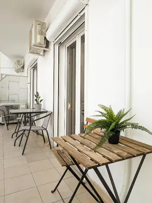 a room with a bench and a table and chairs at Modern&Quiet 2BD apt on a pedestrian in Athens