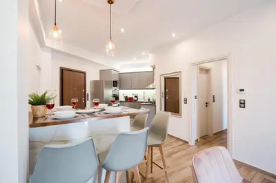 a kitchen and dining room with a table and chairs at Modern 2BD very spacious apt next to metro station in Athens