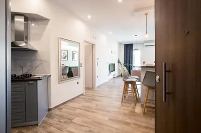 a kitchen and living room with a table and chairs at Modern 2BD very spacious apt next to metro station in Athens