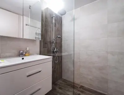 a bathroom with a shower with a sink and a glass shower stall at Iconic 2BD apt next to Historic center and metro in Athens