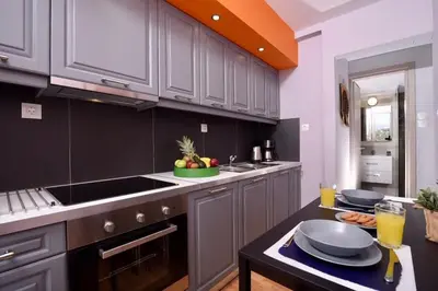 a kitchen with gray cabinets and a black counter top at Iconic 2BD apt next to Historic center and metro in Athens