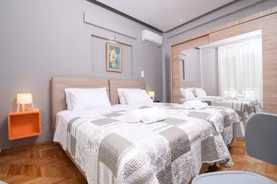 a bedroom with two beds with white sheets and wooden floors at Iconic 2BD apt next to Historic center and metro in Athens