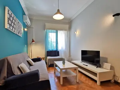 a living room with a couch and a tv at Hidden Gem next to Acropolis&metro in Athens