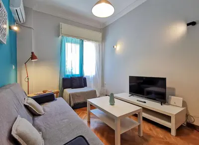 a living room with a couch and a tv and a table at Hidden Gem next to Acropolis&metro in Athens