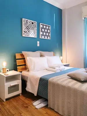 a bedroom with two beds and a blue wall at Hidden Gem next to Acropolis&metro in Athens