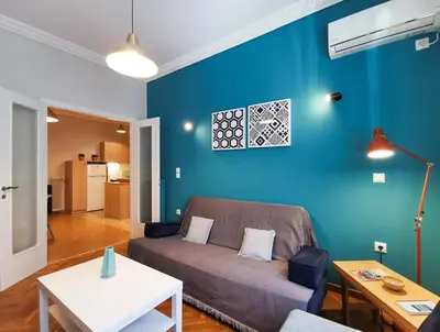 a living room with a couch and a blue wall at Hidden Gem next to Acropolis&metro in Athens