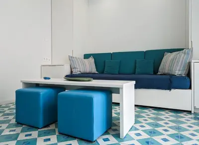 a living room with a blue couch and a table at Greek island styled 1BD apt 500m from the sea in Athens