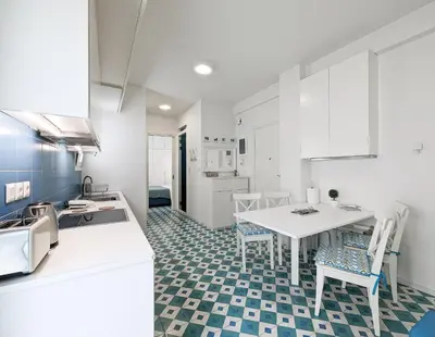 a kitchen with a table and chairs in a room at Greek island styled 1BD apt 500m from the sea in Athens