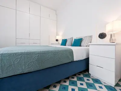a white bedroom with a blue bed and white cabinets at Greek island styled 1BD apt 500m from the sea in Athens