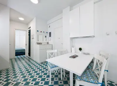 a white kitchen with a white table and chairs at Greek island styled 1BD apt 500m from the sea in Athens
