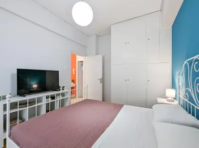 a bedroom with a bed and a flat screen tv at Cozy 1BD apt next to Kallimarmaro Stadium in Athens