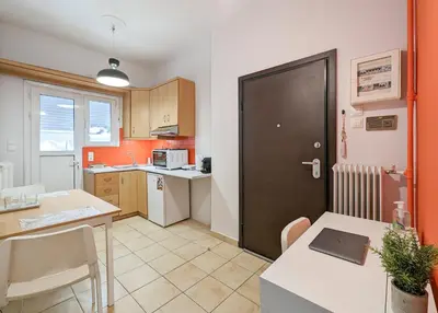 a small kitchen with a table and a door at Cozy 1BD apt next to Kallimarmaro Stadium in Athens
