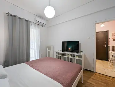 a bedroom with a bed and a flat screen tv at Cozy 1BD apt next to Kallimarmaro Stadium in Athens