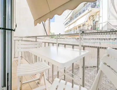 a white table and chairs on a balcony with a cruise ship at Cozy 1BD apt next to Kallimarmaro Stadium in Athens