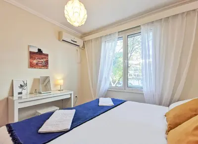 a bedroom with a white bed with a window at Charming 2BD apt next to metro station in Athens