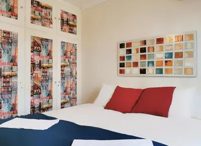 a bedroom with a white bed with red pillows at Charming 2BD apt next to metro station in Athens