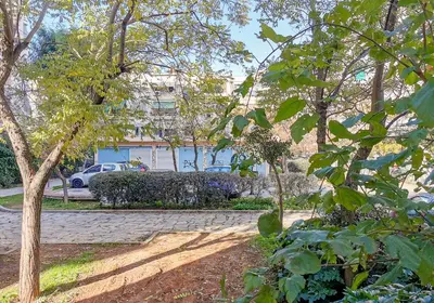 a group of trees with a building in the background at Charming 2BD apt next to metro station in Athens
