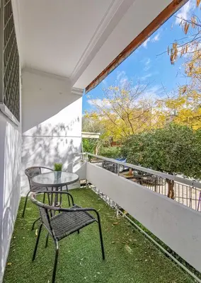 a patio with a table and chairs on a balcony at Charming 2BD apt next to metro station in Athens