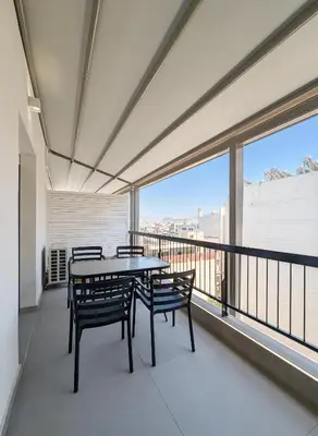 a balcony with a table and chairs on it at Acropolis view 3BD penthouse next to tram and port in Piraeus