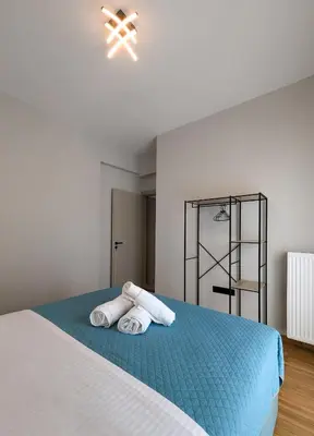a bedroom with a bed with towels on it at Acropolis view 3BD penthouse next to tram and port in Piraeus