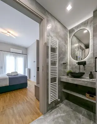 a bathroom with a bed and a sink and a mirror at Acropolis view 3BD penthouse next to tram and port in Piraeus