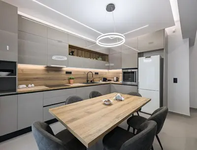 a kitchen with a wooden table and chairs at Acropolis view 3BD penthouse next to tram and port in Piraeus