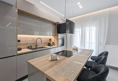 a kitchen with a wooden table and black chairs at Acropolis view 2BD penthouse next to tram and port in Piraeus