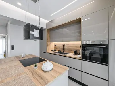 a kitchen with white cabinets and a wooden counter top at Acropolis view 2BD penthouse next to tram and port in Piraeus