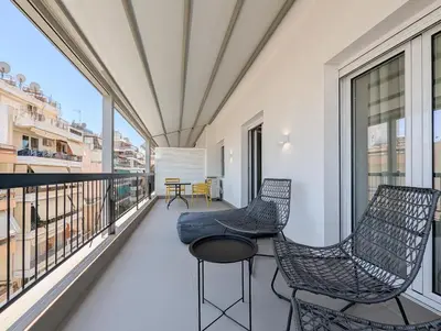a balcony with two chairs and a table at Acropolis view 2BD penthouse next to tram and port in Piraeus