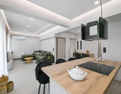 a kitchen and living room with a table and chairs at Acropolis view 2BD penthouse next to tram and port in Piraeus