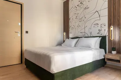 a bedroom with a large bed with a painting on the wall at Phalerus Suites in Athens