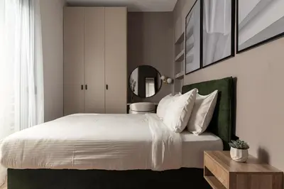 a bedroom with a white bed with a green headboard at Phalerus Suites in Athens