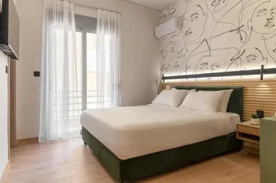 a bedroom with a large bed with a mural on the wall at Phalerus Suites in Athens